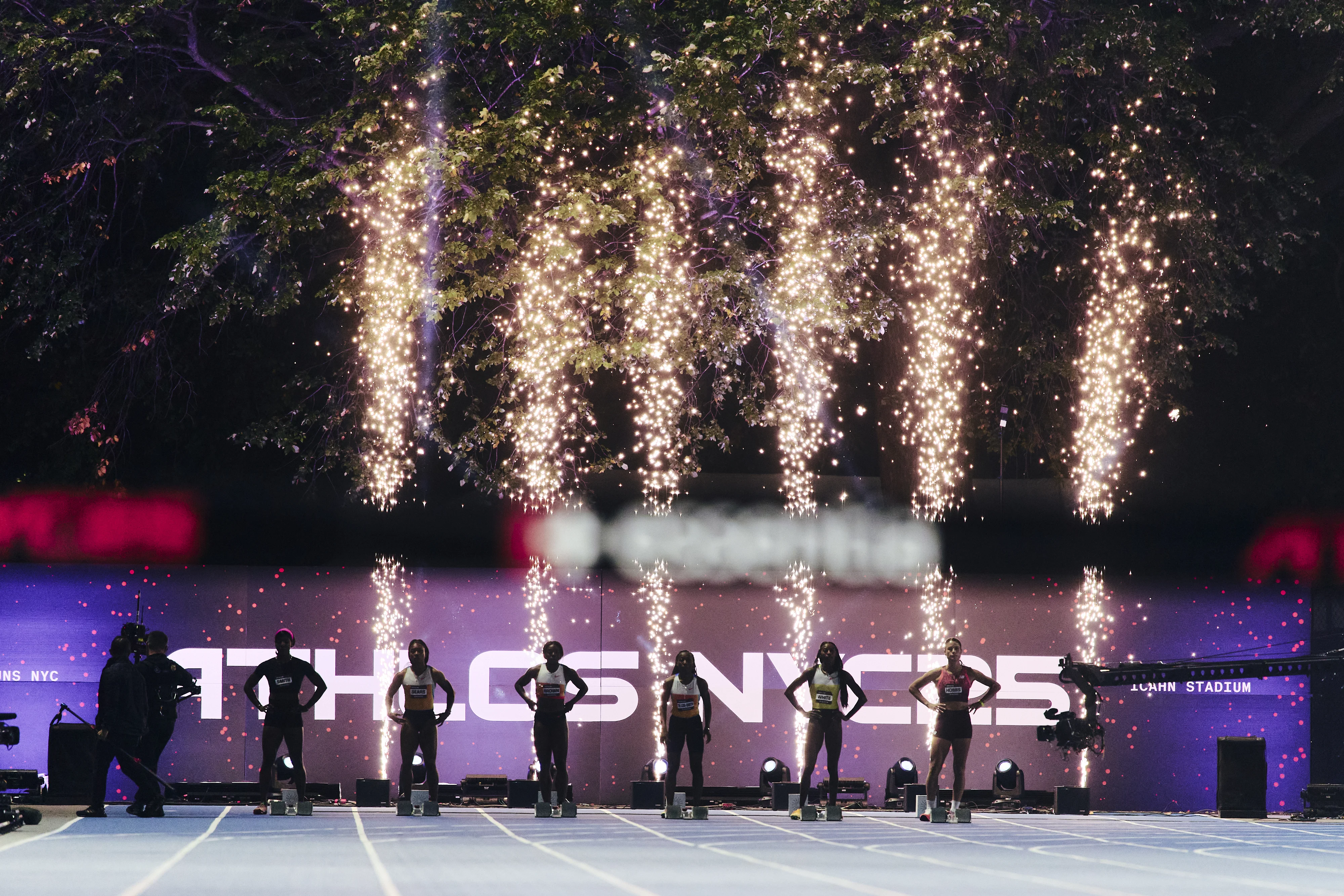ATHLOS athletes lined up beneath fireworks